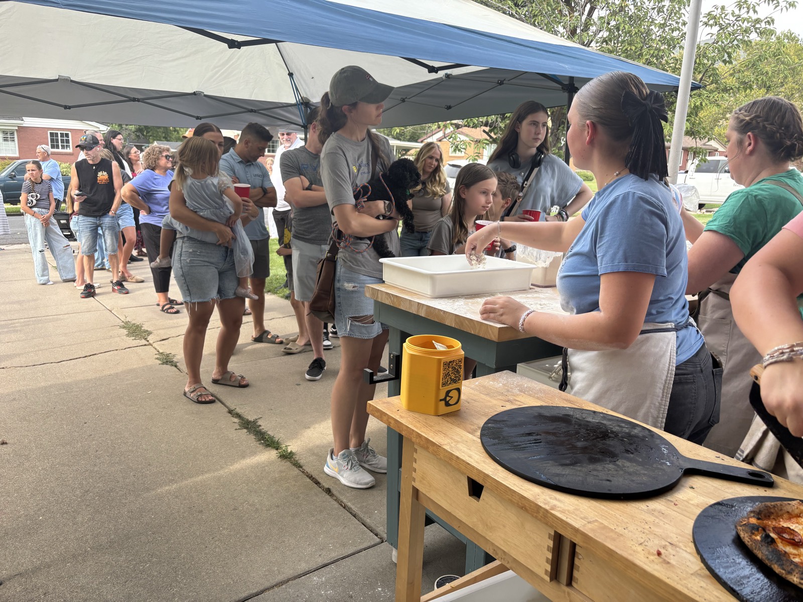 Guests lined up at the dough station during a neighborhood pizza event