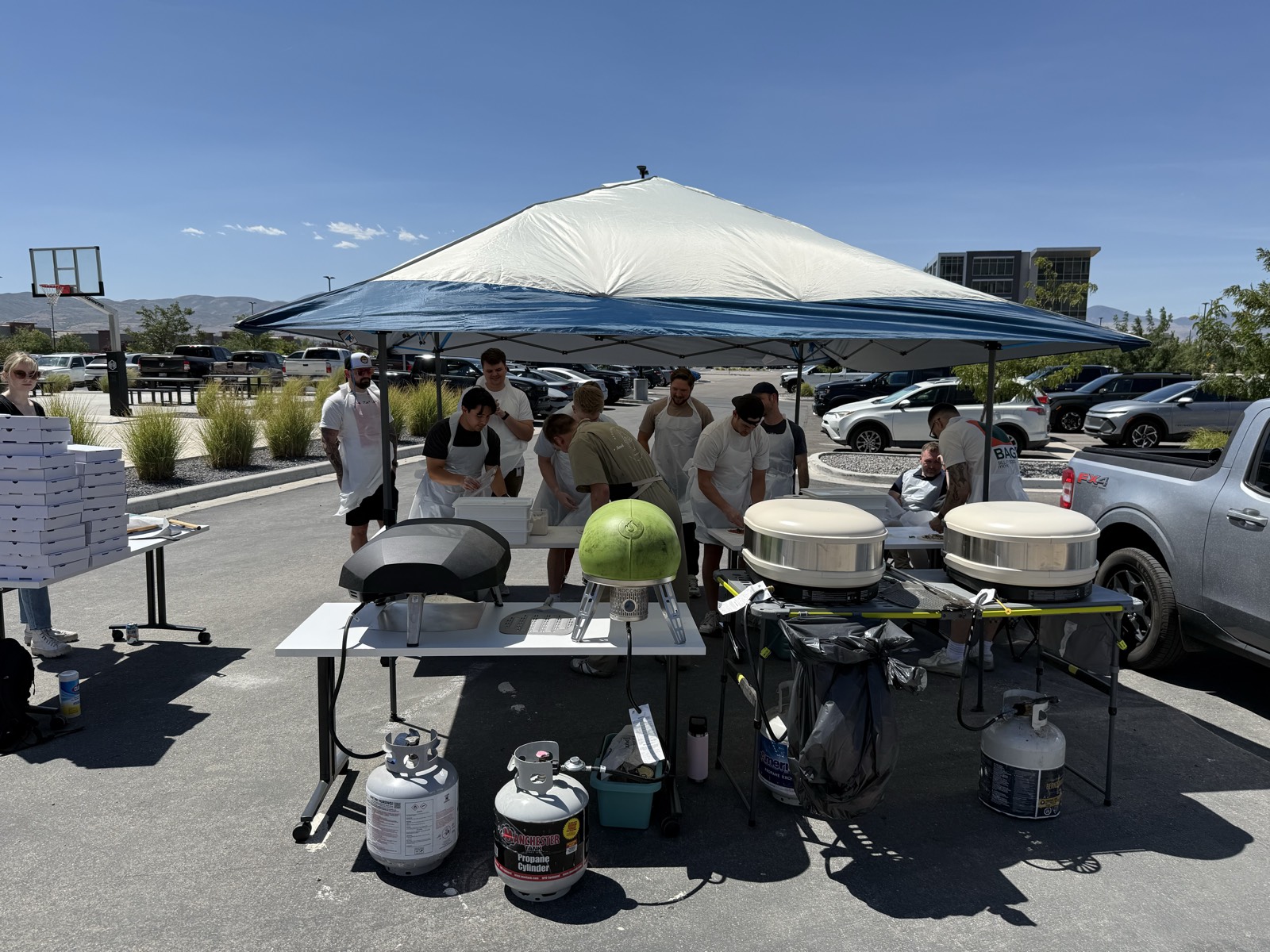 The Backyard Brick Oven team cooking on multiple ovens at a large outdoor event
