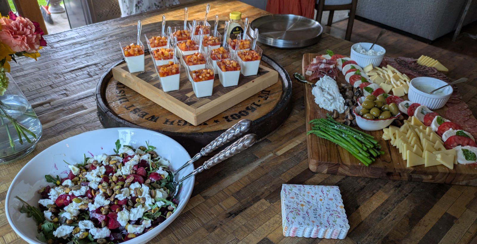 Catered spread with panna cotta, charcuterie board, and beet & goat cheese salad